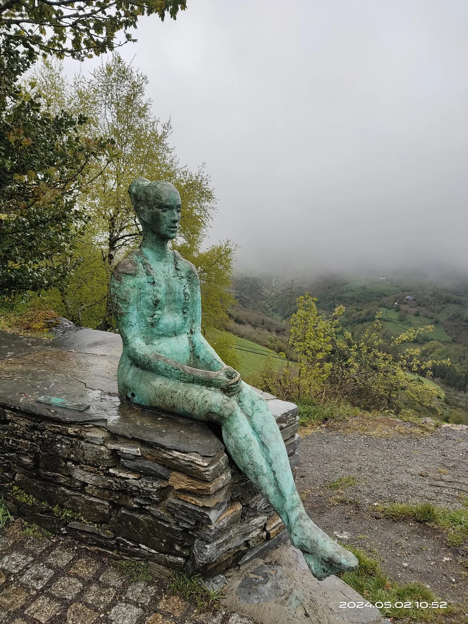 歐塞夫雷羅的朝聖者雕像，背景是雲霧繚繞的加利西亞山景
