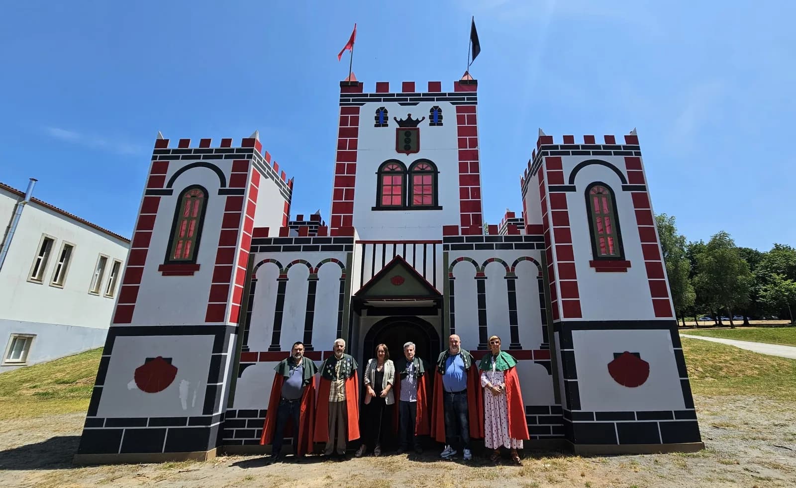 阿爾蘇阿 San Xoán 慶典的木造城堡 Castelo de Santa María,前方站著身穿紅披風的兄弟會成員